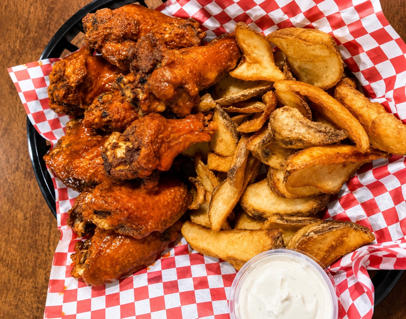 Basket of jumbo wings with potato wedges and ranch